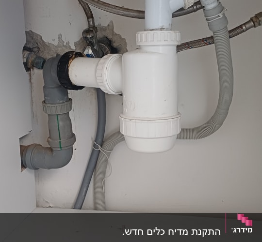 צנרת מתחת לכיור עם מגבת צהובה